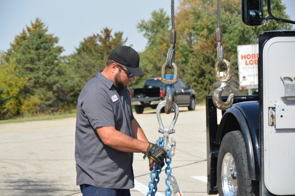 A Tony's employee expertly securing chains for medium-duty towing services in Northern Iowa.