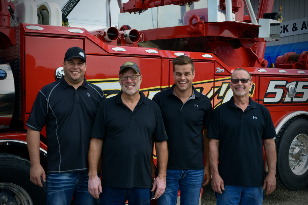 Tony, his two sons, and brother standing together, representing the family-oriented values of Tony's Tire, Truck & Towing.