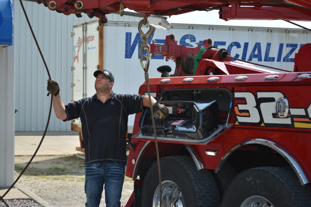Tony's skilled team loading with precision using a wrecker for reliable towing services in Northern Iowa.