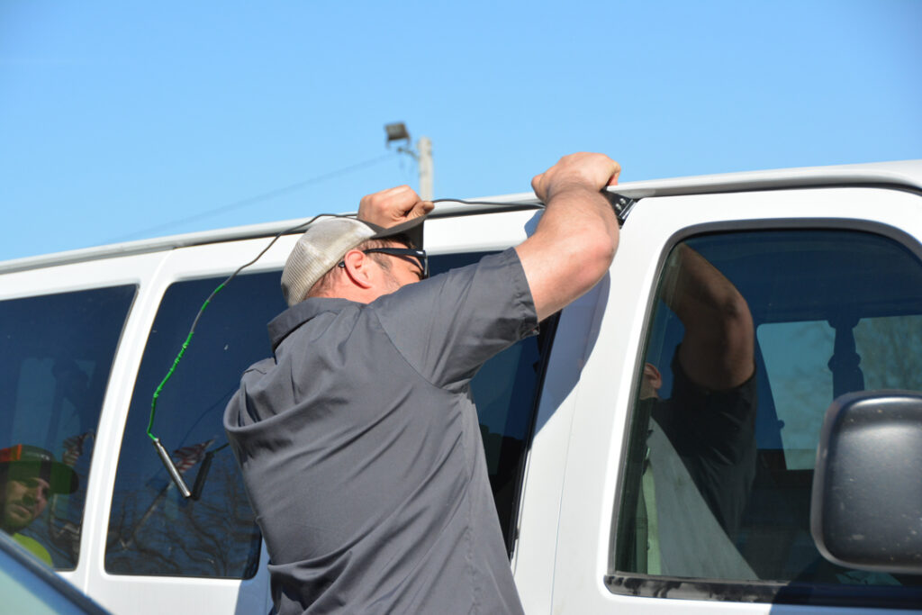 Tony's employee unlocking a car door, providing professional assistance in Iowa.