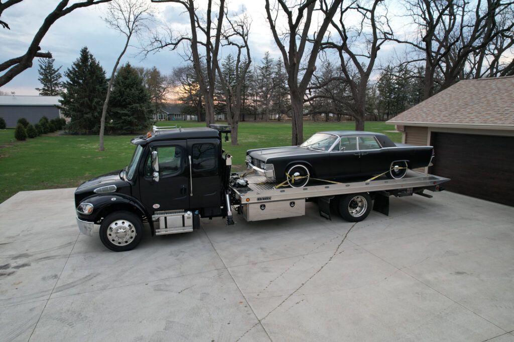 A classic car securely loaded on Tony's flatbed tow truck, ensuring safe and reliable transport in Northern Iowa.