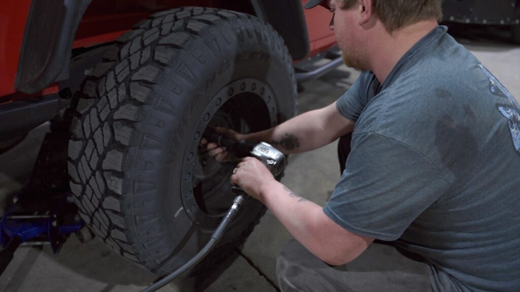 Tony's skilled technician repairing a tire, ensuring road safety in Northern Iowa.