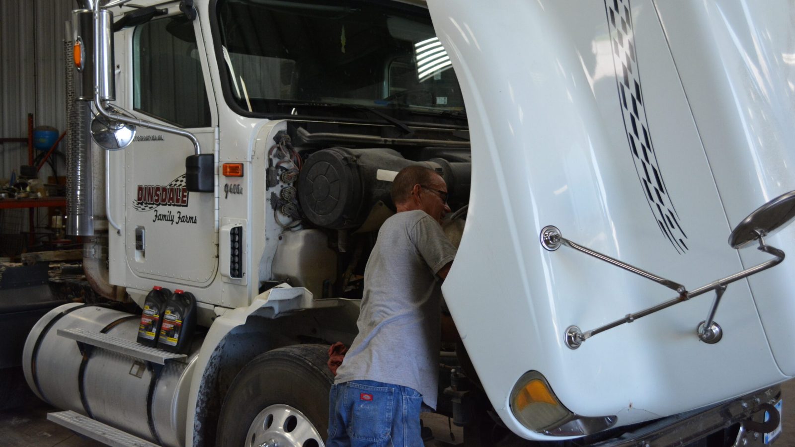 Expert technician from Tony's Tire, Truck & Towing conducting repairs under the hood of a semi truck.